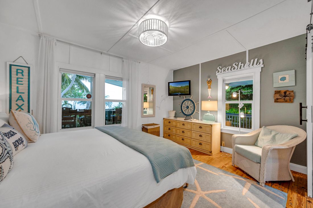 Master bedroom with queen bed, closet, TV, and windows