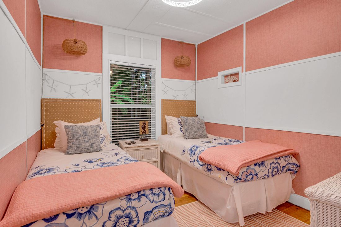 Coral Room, 2 twin beds with a TV, window, and dresser