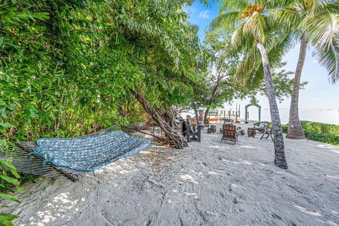 Fire pit, hammock, and sand area at Butterfly House Islamorada