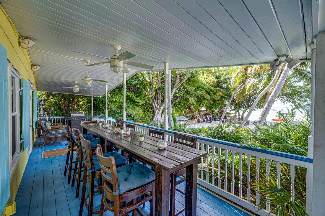 Patio with large table, outdoor seating, and waterfront views at Butterfly House