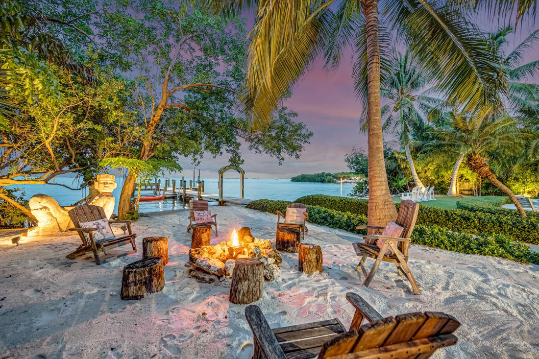 Fire pit with chairs, sand area, and private dock at Butterfly House Islamorada